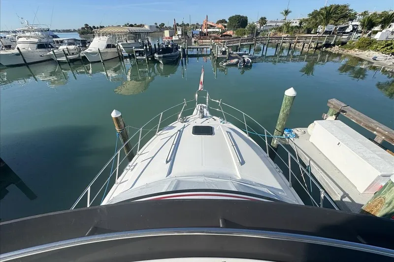Slide: The Image of 1994 President 445 Sundeck yacht docked at a marina, surrounded by calm water and other boats. - 43