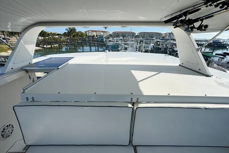Slide: The Image of 1994 President 445 Sundeck yacht interior with marina view, featuring spacious seating and fishing rods. - 46
