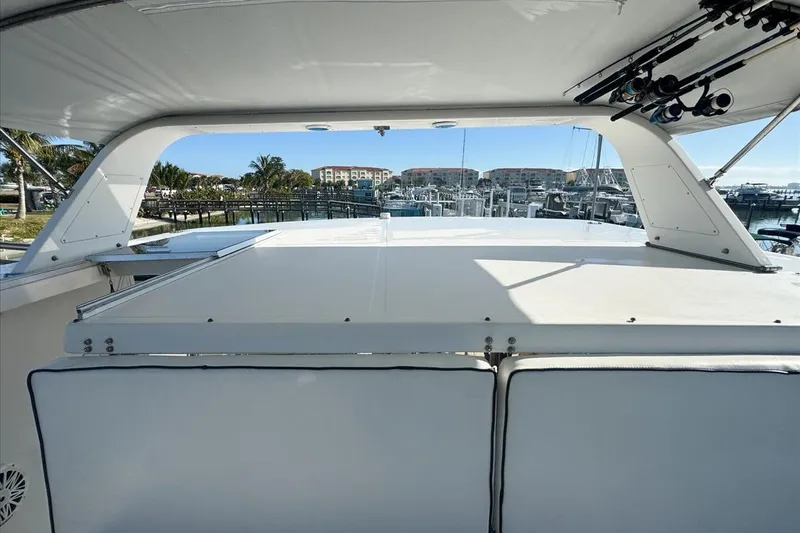 Slide: The Image of 1994 President 445 Sundeck yacht interior with marina view, featuring fishing rods and seating area. - 47