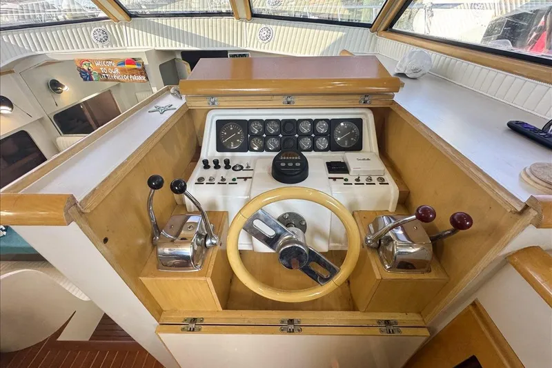 Slide: The Image of 1994 President 445 Sundeck helm with wooden steering wheel and control panel. - 68