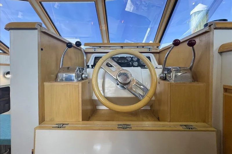 Slide: The Image of 1994 President 445 Sundeck helm with wooden steering wheel and dual throttle controls. - 70