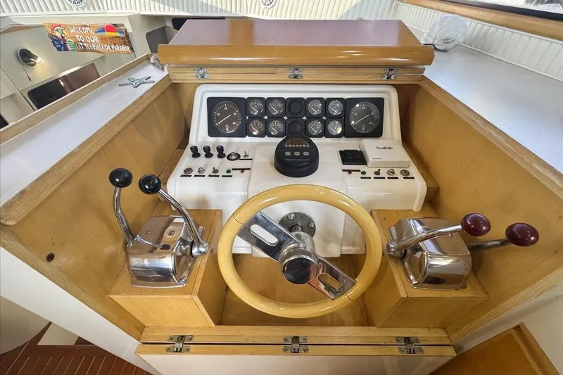 Slide: The Image of 1994 President 445 Sundeck yacht helm with wooden steering wheel and control levers. - 71