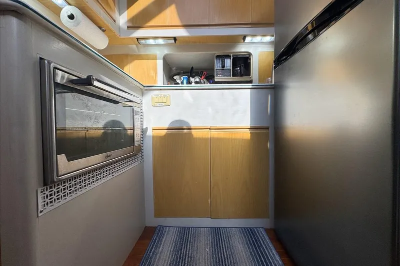 Slide: The Image of Compact kitchen area in a 1994 President 445 Sundeck yacht, featuring modern appliances. - 85