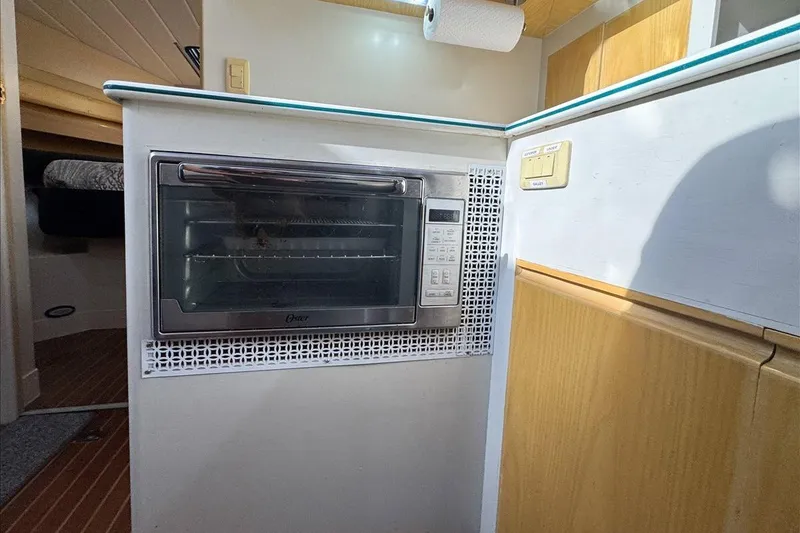 Slide: The Image of 1994 President 445 Sundeck yacht kitchen with built-in oven and wooden cabinetry. - 87