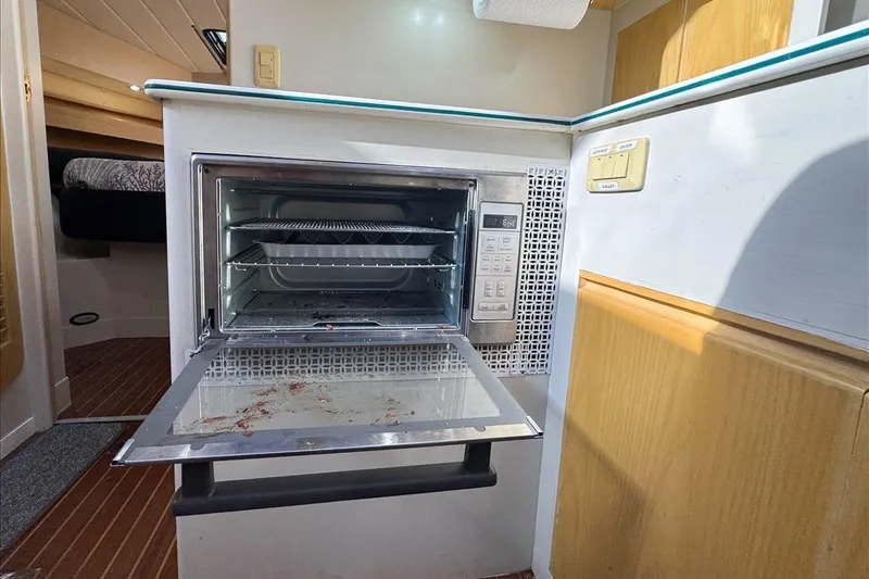 Slide: The Image of 1994 President 445 Sundeck yacht interior with open microwave oven in kitchen area. - 88