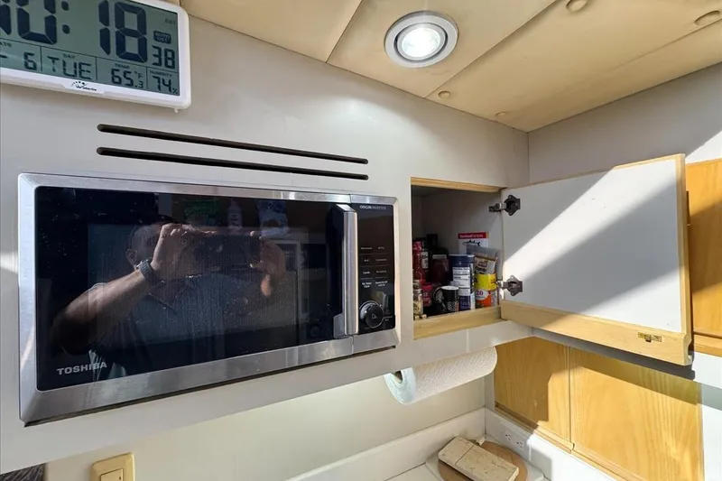 Slide: The Image of Kitchen area of 1994 President 445 Sundeck with microwave and open cabinet. - 91