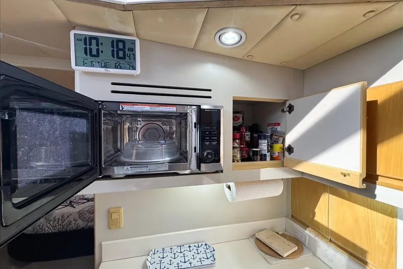 Slide: The Image of Kitchen area in 1994 President 445 Sundeck yacht with microwave and open cabinet. - 92