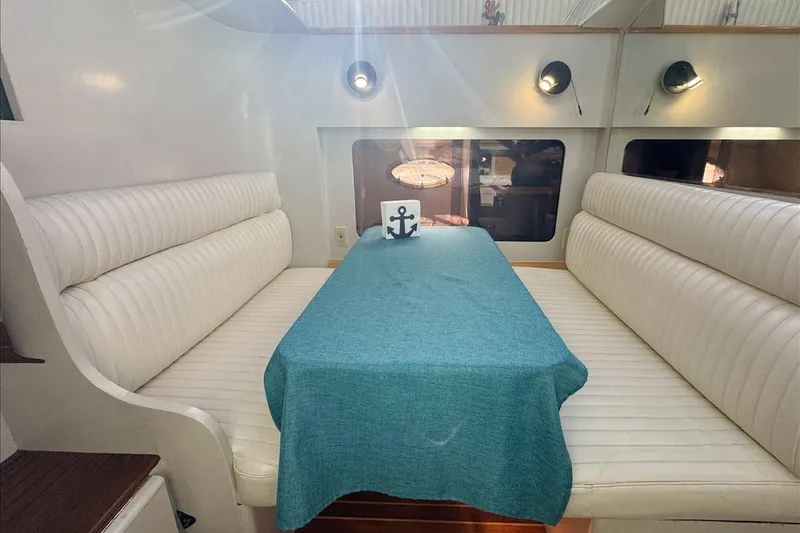 Slide: The Image of Interior of 1994 President 445 Sundeck yacht with white seating and teal tablecloth. - 94