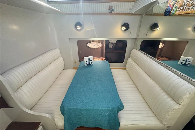 Slide: The Image of Interior of 1994 President 445 Sundeck yacht with white seating and blue tablecloth. - 96