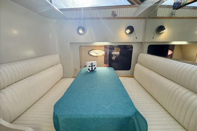 Slide: The Image of Interior of 1994 President 445 Sundeck yacht with white seating and teal tablecloth. - 97