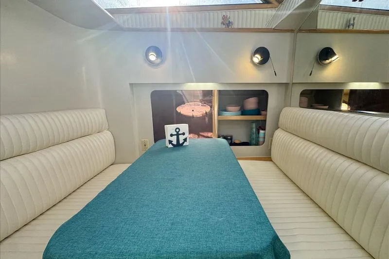 Slide: The Image of Interior of 1994 President 445 Sundeck yacht with teal tablecloth and white seating. - 98