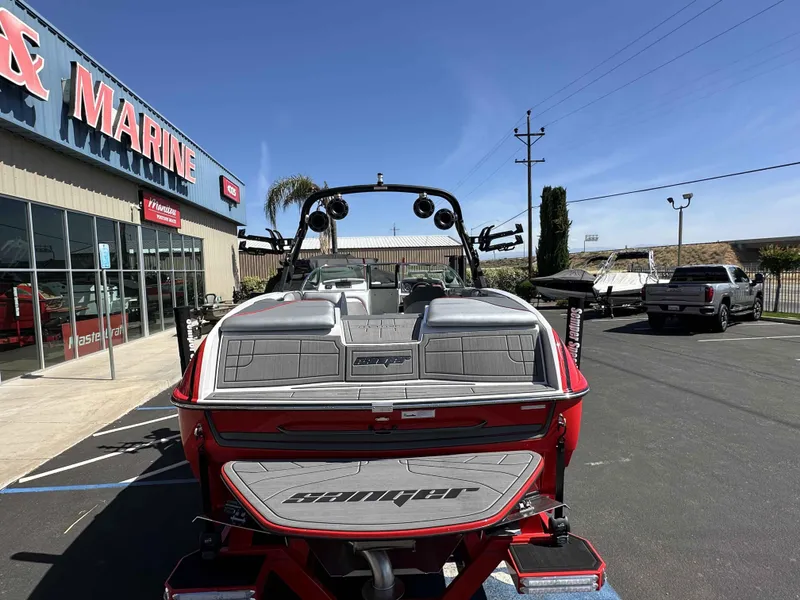 Slide: The Image of 2024 Sanger 231 SL boat parked outside a marine dealership on a sunny day. - 5