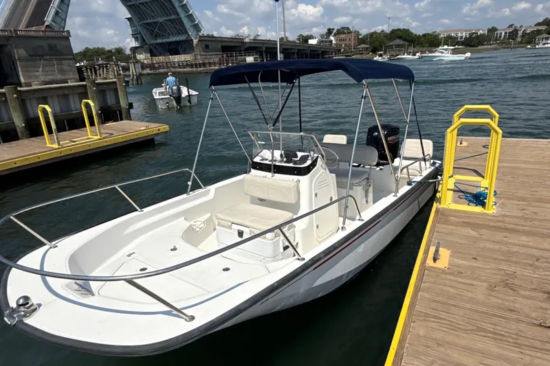 Slide: The Image of 2022 Boston Whaler 170 Montauk boat docked near a raised drawbridge on a sunny day. - 13