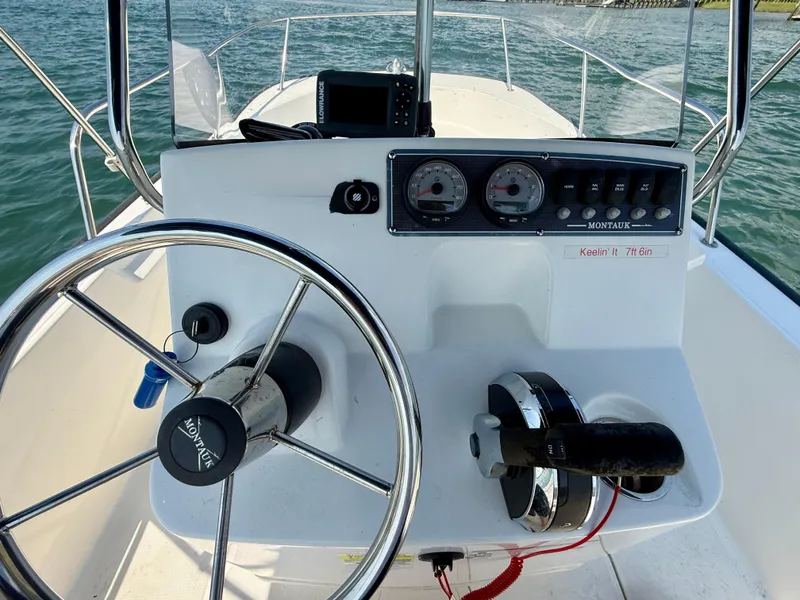 Slide: The Image of 2022 Boston Whaler 170 Montauk boat dashboard with steering wheel and controls. - 19