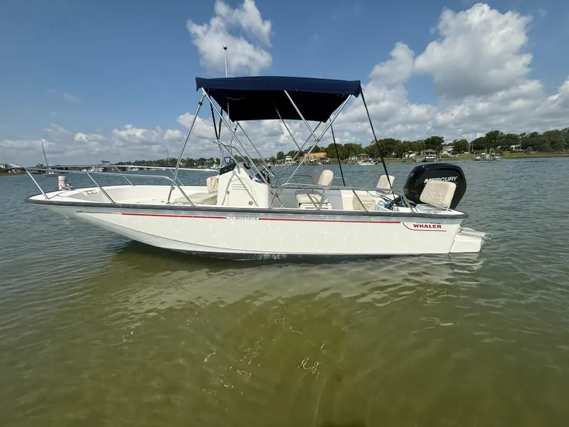 Slide: The Image of 2022 Boston Whaler 170 Montauk boat on calm water under blue sky. - 2