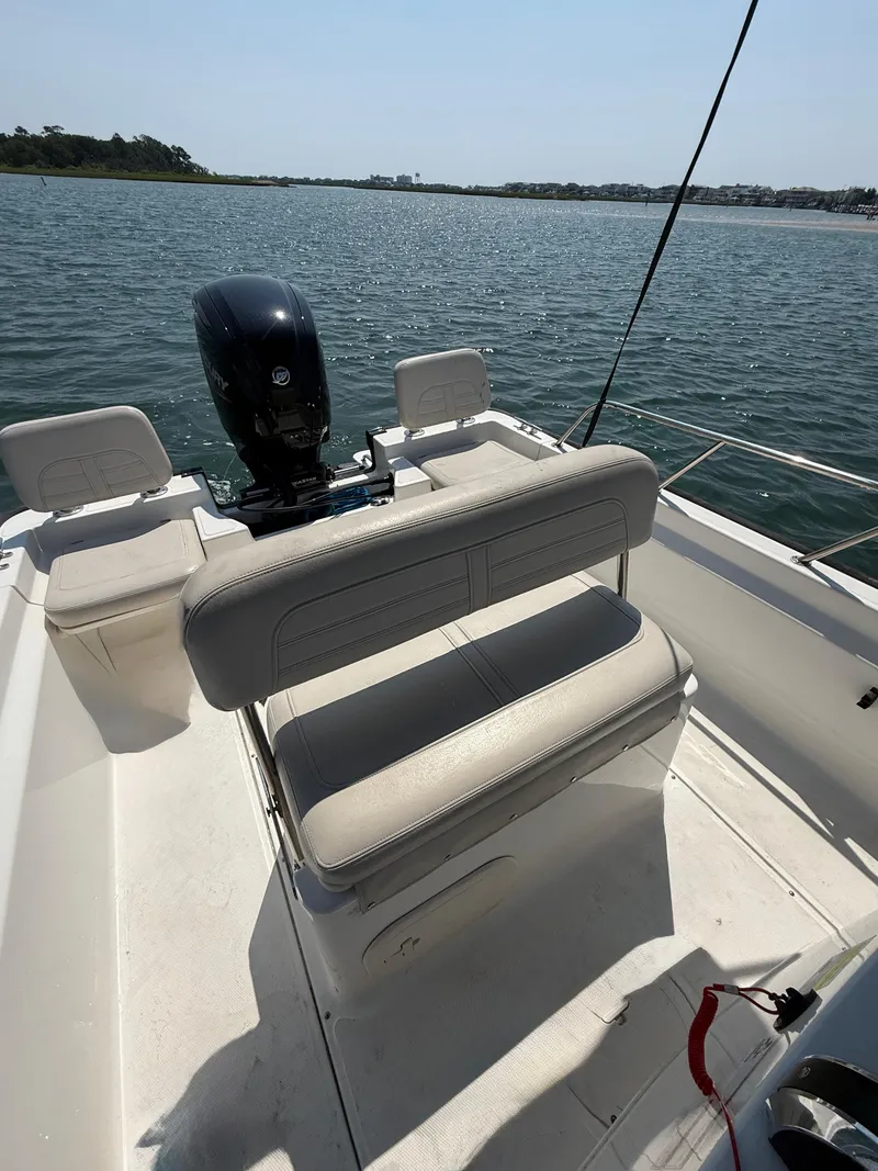 Slide: The Image of 2022 Boston Whaler 170 Montauk boat interior with seating and outboard motor on a sunny day. - 20