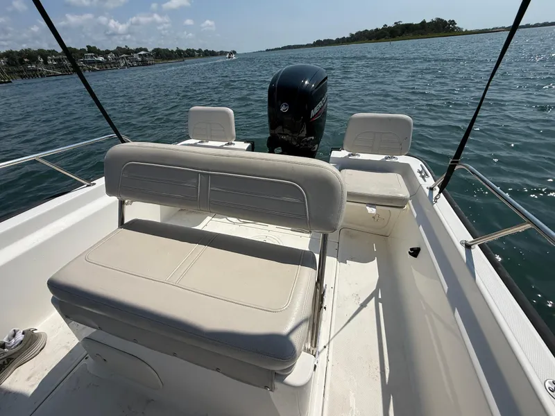 Slide: The Image of 2022 Boston Whaler 170 Montauk boat interior with seating and outboard motor on the water. - 21