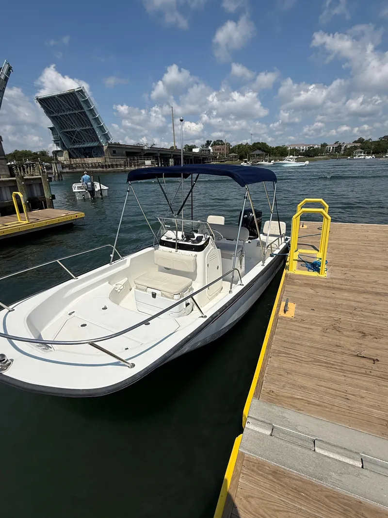 Slide: The Image of 2022 Boston Whaler 170 Montauk docked near open drawbridge under blue sky. - 28