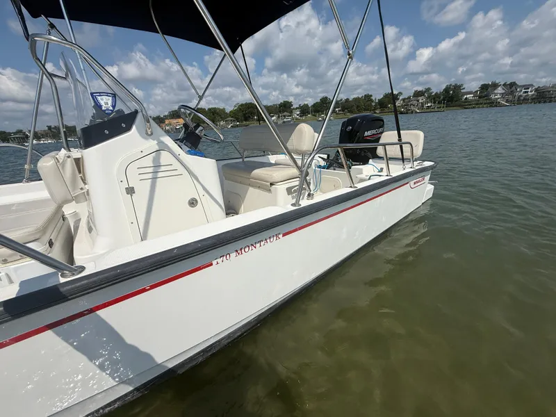Slide: The Image of 2022 Boston Whaler 170 Montauk boat on calm water under a blue sky. - 6