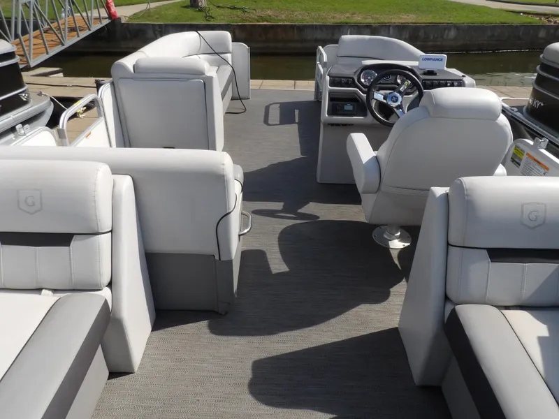 Slide: The Image of 2022 Sweetwater 2286 Tritoon interior with plush seating and modern steering console. - 4