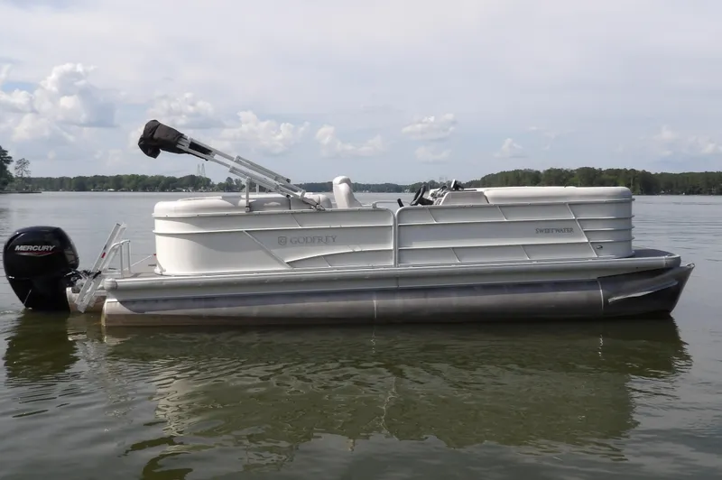 Slide: The Image of 2022 Sweetwater 2286 Tritoon pontoon boat on a calm lake. - 6