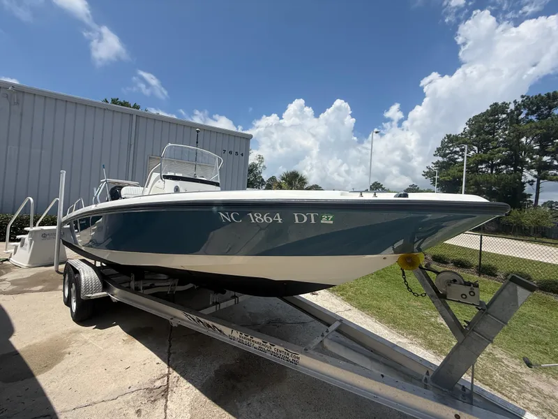 Slide: The Image of 2011 Boston Whaler 230 Dauntless boat on trailer, parked outdoors under a clear sky. - 10
