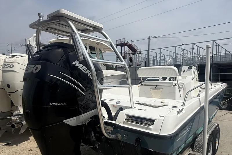 Slide: The Image of 2011 Boston Whaler 230 Dauntless boat with Mercury Verado engine, docked outdoors. - 14