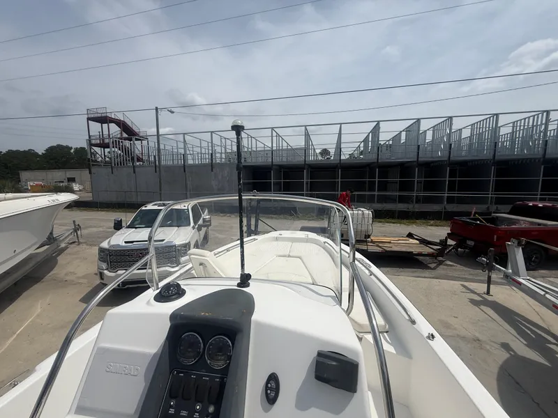 Slide: The Image of 2011 Boston Whaler 230 Dauntless boat docked near vehicles and trailers. - 15
