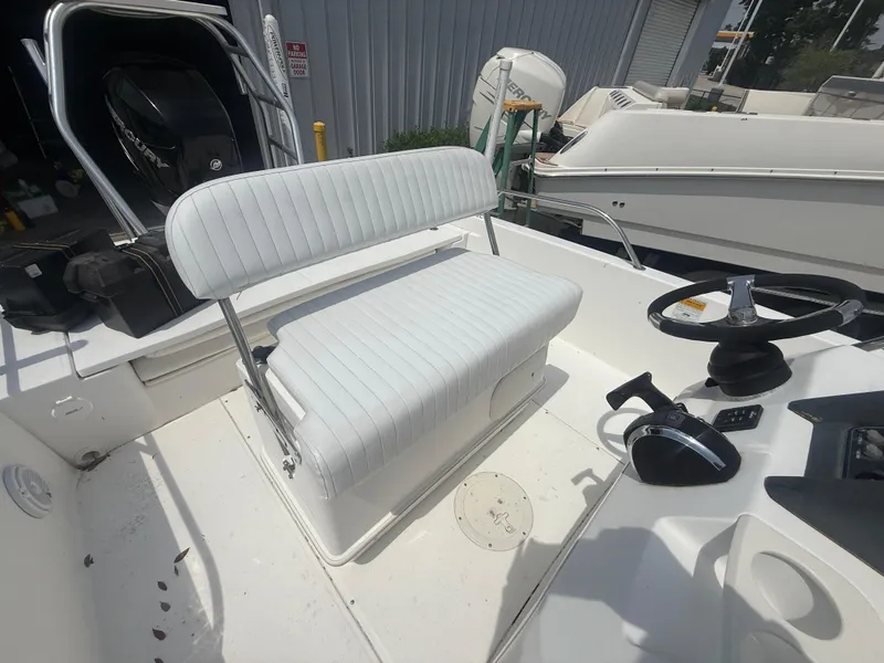 Slide: The Image of 2011 Boston Whaler 230 Dauntless boat interior with white seating and steering controls. - 19