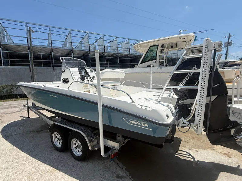 Slide: The Image of 2011 Boston Whaler 230 Dauntless boat on trailer, featuring Mercury engine. - 2