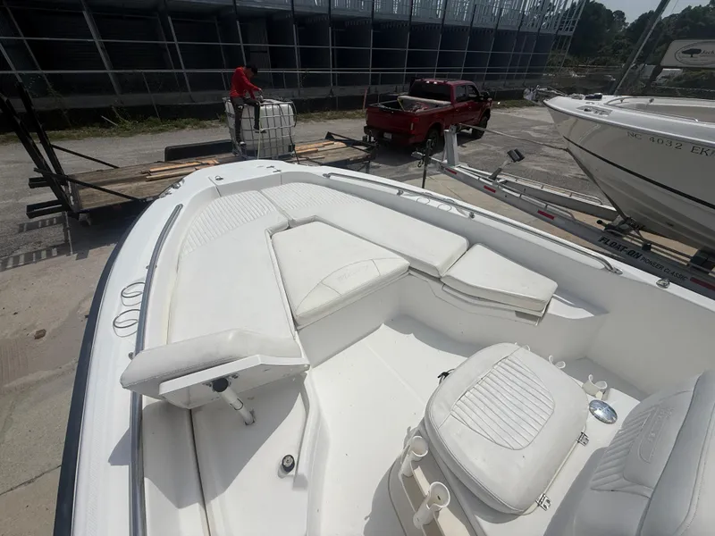 Slide: The Image of 2011 Boston Whaler 230 Dauntless boat with white seating and deck, docked near a red truck. - 21