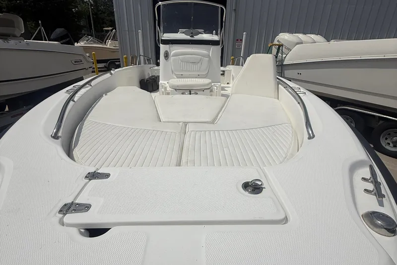 Slide: The Image of 2011 Boston Whaler 230 Dauntless boat, white deck, spacious seating, docked outdoors. - 22