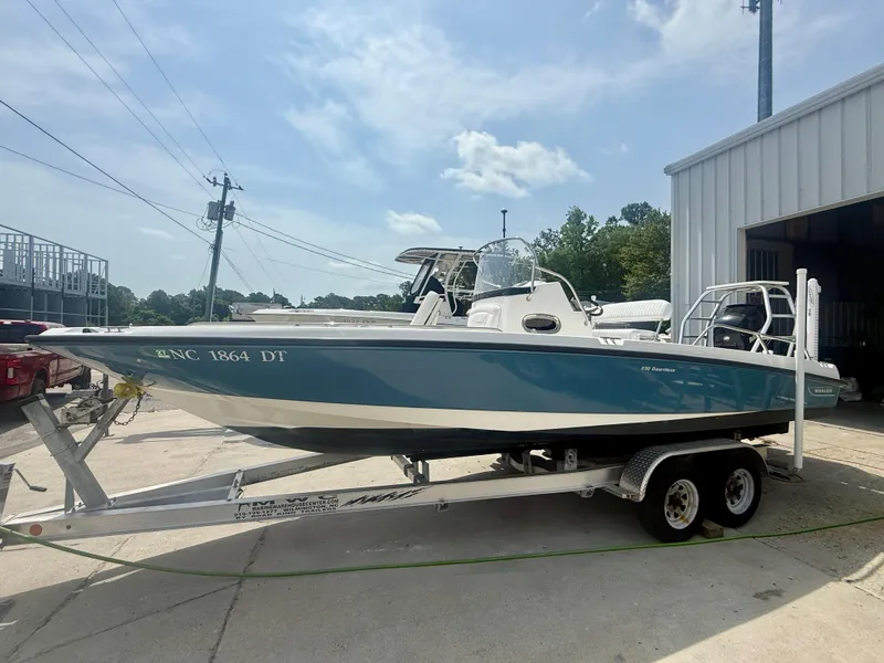 Slide: The Image of 2011 Boston Whaler 230 Dauntless boat on trailer, parked outdoors near a building. - 7