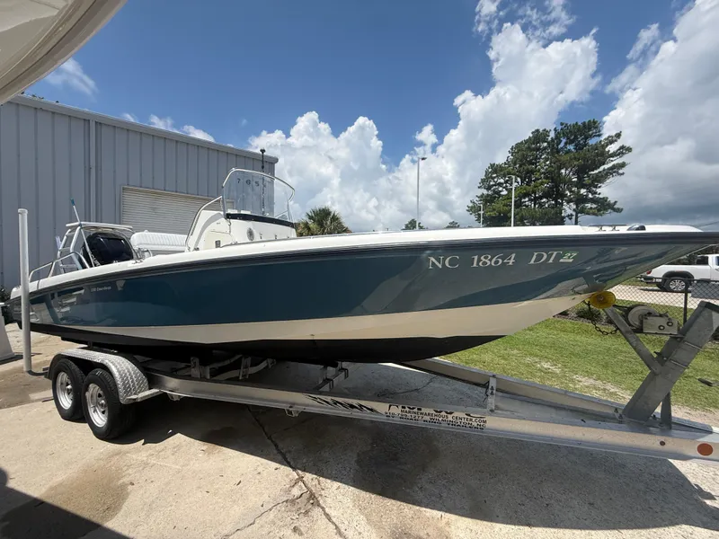 Slide: The Image of 2011 Boston Whaler 230 Dauntless boat on trailer, parked outdoors under cloudy sky. - 9