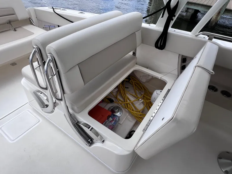 Slide: The Image of Boston Whaler 320 Vantage 2022 boat seat storage compartment with equipment visible. - 28