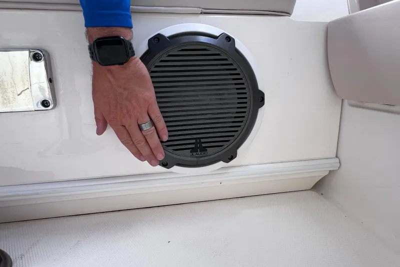 Slide: The Image of Hand touching speaker on 2022 Boston Whaler 320 Vantage boat interior. - 31