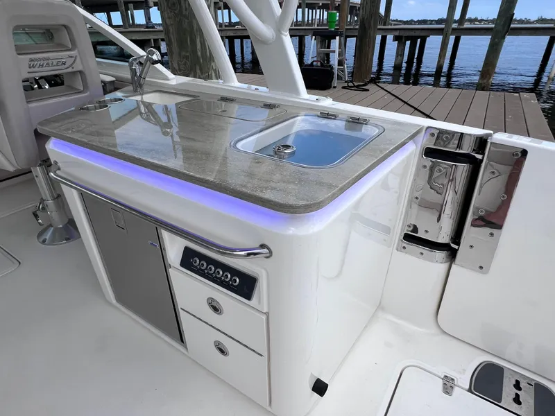 Slide: The Image of Boston Whaler 320 Vantage 2022 boat interior with sink and storage compartments. - 32