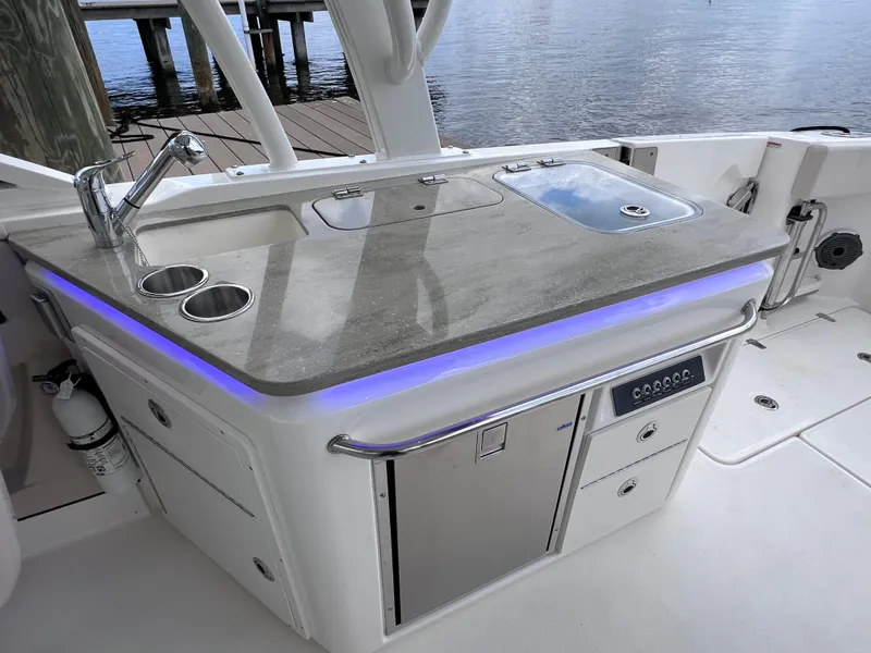 Slide: The Image of 2022 Boston Whaler 320 Vantage boat kitchen area with sink and storage. - 33