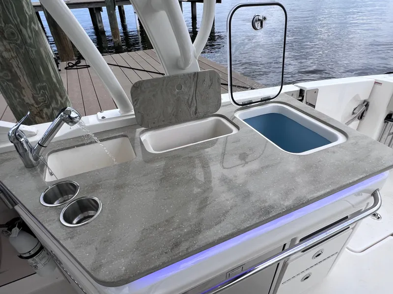 Slide: The Image of Boston Whaler 320 Vantage 2022 boat sink and countertop with storage compartments. - 35
