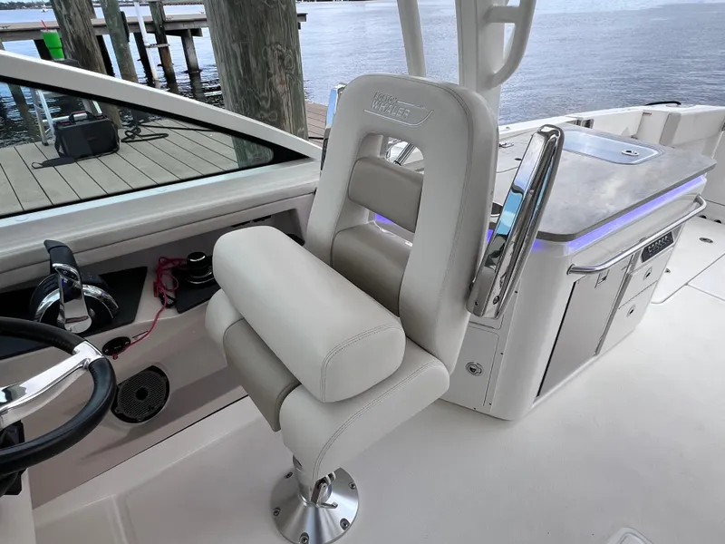 Slide: The Image of 2022 Boston Whaler 320 Vantage boat interior with joystick control, docked by the water. - 45