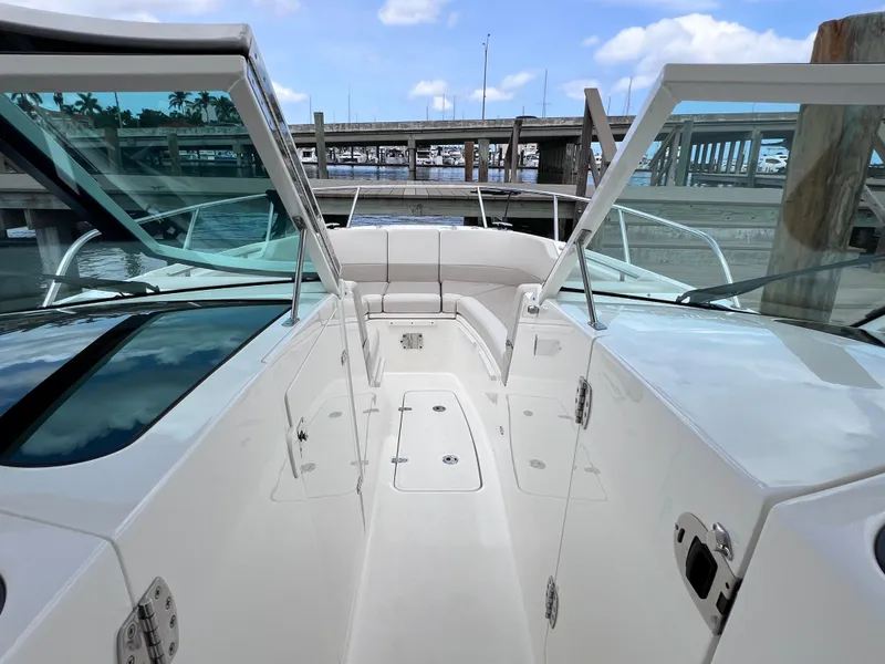 Slide: The Image of 2022 Boston Whaler 320 Vantage boat with joystick, docked at marina under blue sky. - 47