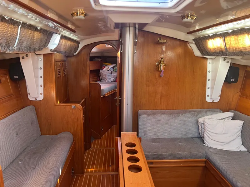 Slide: The Image of Interior of a 1985 Wauquiez Pretorian Sloop, featuring cozy wooden furnishings and seating. - 12