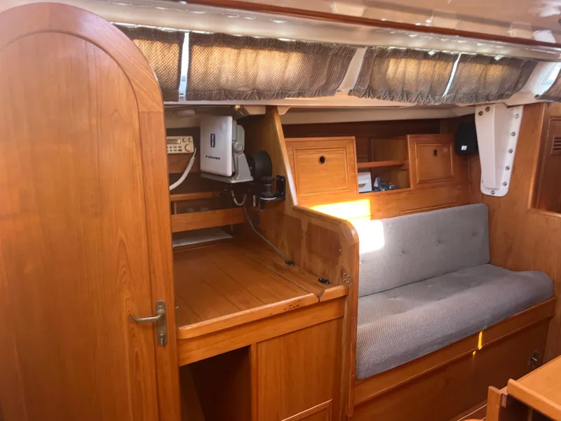Slide: The Image of Interior of 1985 Wauquiez Pretorian Sloop, featuring wooden cabinetry and a cushioned seating area. - 22