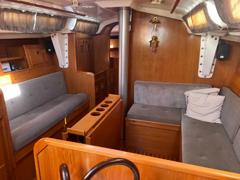 Slide: The Image of 1985 Wauquiez Pretorian Sloop interior with wooden finish and gray seating. - 23