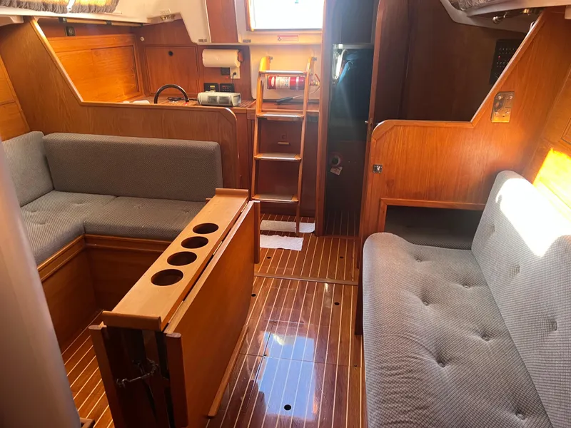 Slide: The Image of Interior of 1985 Wauquiez Pretorian Sloop with wooden finish and cushioned seating. - 26