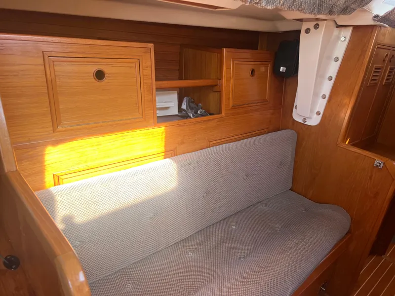 Slide: The Image of 1985 Wauquiez Pretorian Sloop interior with wooden cabinetry and cushioned seating. - 27