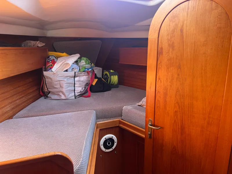 Slide: The Image of 1985 Wauquiez Pretorian Sloop cabin interior with wooden finish and storage area. - 28