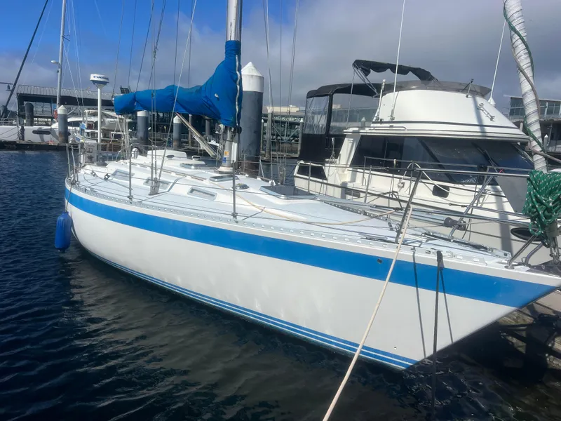 Slide: The Image of 1985 Wauquiez Pretorian Sloop docked at marina, featuring blue accents and sleek design. - 3