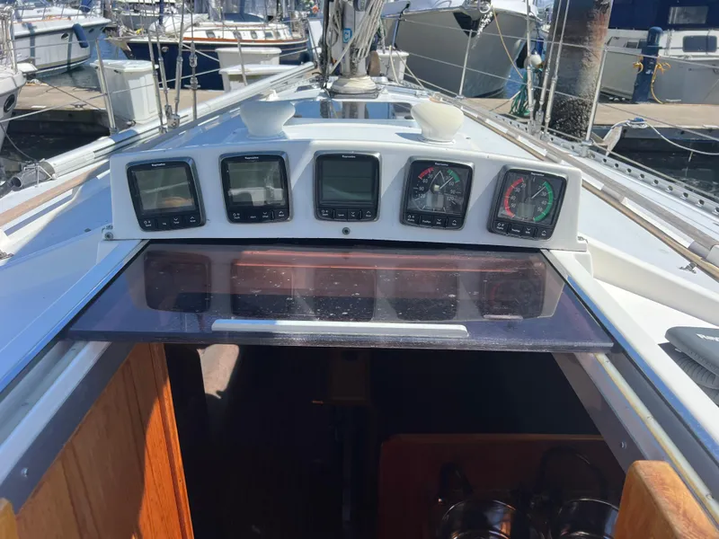 Slide: The Image of 1985 Wauquiez Pretorien Sloop cockpit with navigation instruments and open hatch. - 37