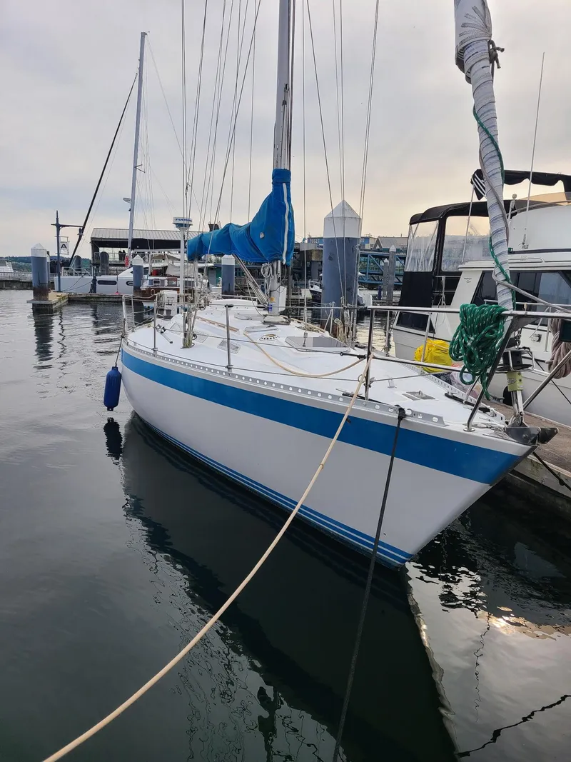Slide: The Image of 1985 Wauquiez Pretorian Sloop docked at marina, featuring blue and white hull. - 4
